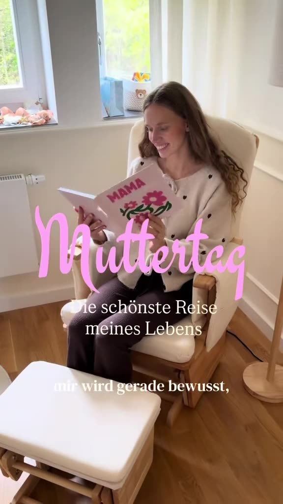Melina sitzt im Stillsessel und blättert in einem Fotobuch